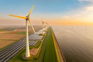Windturbinen und Sonnenkollektoren an einem Seeufer