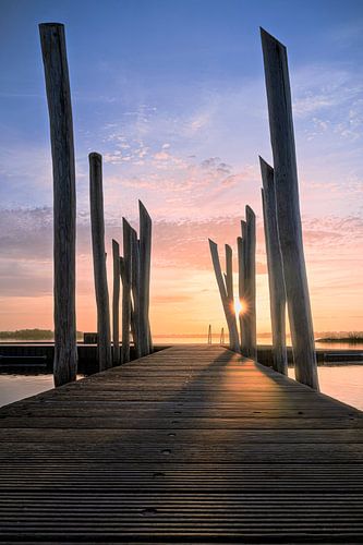 Houten palen van Pier in gouden uur gloed bij zonsopkomst van Fotografiecor .nl