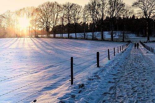 Wandelaars in sneeuwlandschap met late middagzon
