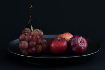 Stilleven met rode druiven en pruimen