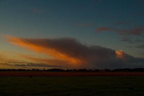 De opkomende zon kleurt de wolken