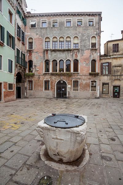 De vieux bâtiments et un puits dans le vieux centre de Venise, Italie par Joost Adriaanse