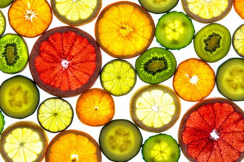 Collage van schijfjes fruit en groente met een witte achtergrond.