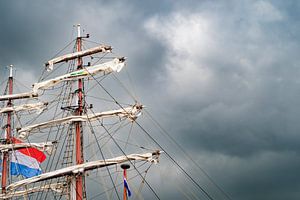 Alter Segelschiffmast und Segel mit dunklen Wolken