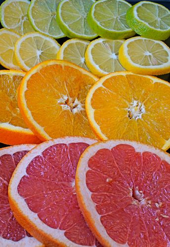 Citrusvruchten in plakjes gesneden en op een zwarte serveerplank gelegd