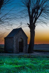 kapel midden in het weiland tijdens een kleurijke zonsondergang van Kim Willems