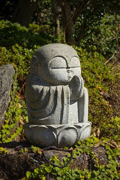Japanese ancient historic stone Buddha statue in park by Frans Rombout