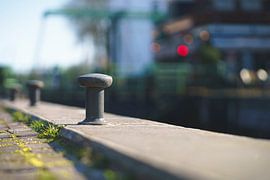 Quay bathed in sunlight with long shadows by the lock in Blokzijl by Fotografiecor .nl