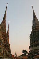 Tweede zicht op twee stoepa's tegen de hemel bij Wat Pho