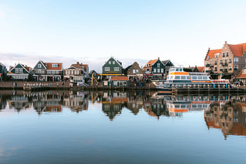 Een uitzicht op de dijk en boot naar Marken in Volendam