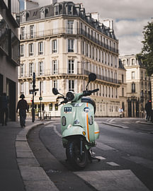 Un scooter vert menthe dans une rue de Paris