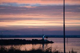 Lighthouse in the harbour at sunset by Martin Köbsch