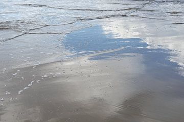 Onopvallende golven en weerspiegeling in het natte zand van Adriana Mueller
