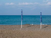 Blauw met witte parasols aan het strand