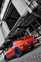Oranje Porsche 911 voor vervallen pand in zwart wit
