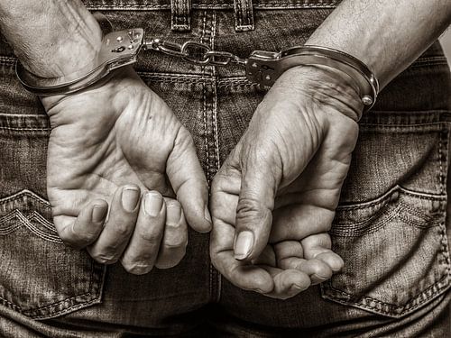 Handen in handboeien