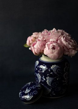 Roze pioenrozen in een blauw vaas