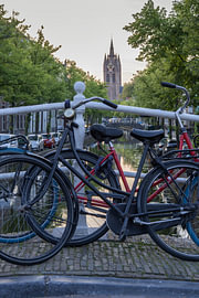 Faire du vélo sur un pont avec vue sur l'Oude Kerk à Delft sur Heidi Bol