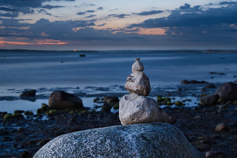 Stone pyramid on the Baltic Sea with a view of the sea at sunset and blue hour by Martin Köbsch