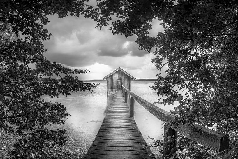 Voetgangersbrug met boothuis aan het meer in Beieren in zwart-wit. van Manfred Voss, Zwart-Wit Fotografie