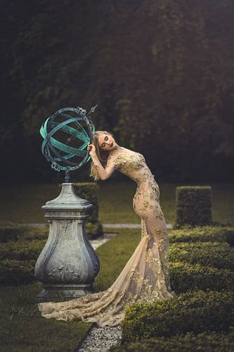 Sensuele jonge vrouw bij zonnewijzer in goudkleurige sexy jurk.