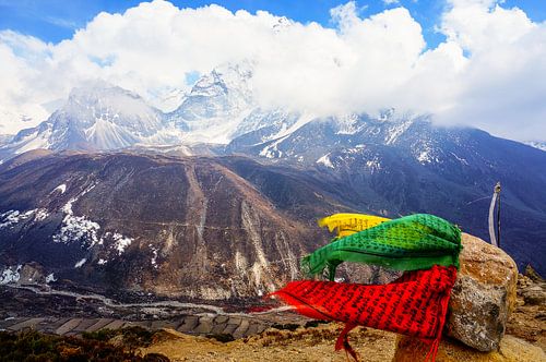 Prayer flags blowing in the wind, high on a Himalayan peak.