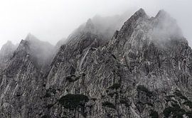 Dramatic mountain peaks surrounded by mist in the Austrian Alps. by André Post