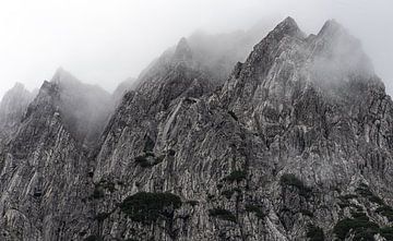 Dramatische bergtoppen omringt door nevel in de Oostenrijkse Alpen. van André Post