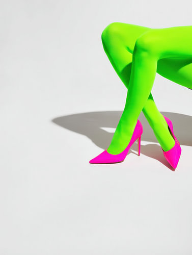 Jambes vertes croisées avec des escarpins roses