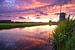Zonsondergang in een landschap met molen en sloot van iPics Photography