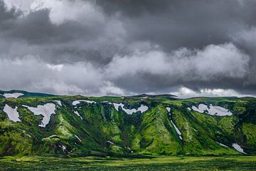 Dunkle Wolken über moosgrünen Bergen in Laki, Island