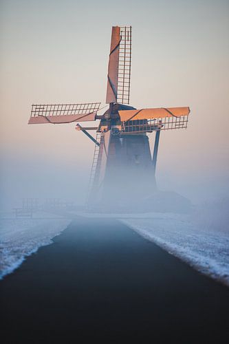 Moulin à l'aube de l'hiver, entouré de neige et de brouillard