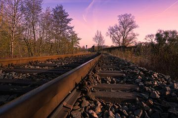 Spoorlijn onder paarse zonsondergang van Raphotography