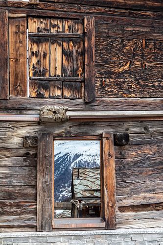 The Alpine panorama reflected in a window in the hamlet of Findeln