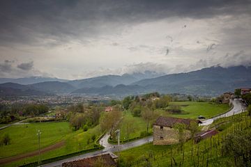 Bedrohliche Wolken über der grünen Landschaft der Toskana von Joost Adriaanse