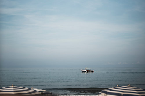 Boot op Zee onder Zachte Blauwe Lucht aan Rustige Kust