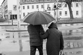 Gepensioneerd stel in de regen bij een stoplicht in de stad Zwart-wit fotografie Straatfotografie van Animaflora PicsStock