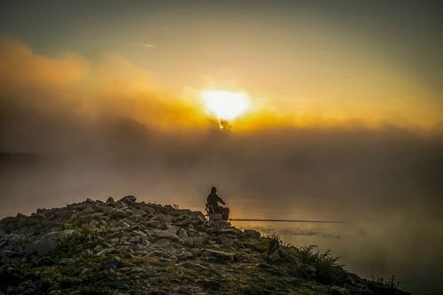 Fisherman on the river IJssel as the sun rises by Gerard Boerkamp