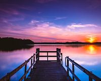 Zonsondergang bij het water op een steiger.