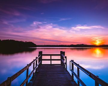 Zonsondergang bij het water op een steiger. van Jeffrey van Roon