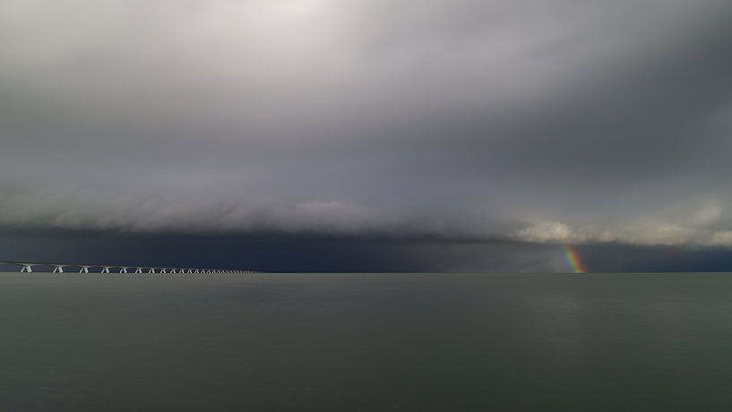 The Zeeland Bridge and a winter shower with rainbow by Jan Jongejan