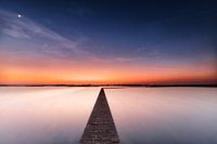 Houten voetpad bij zonsondergang