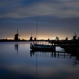 Historische Nederlandse windmolens langs een breed kanaal in Kinderdijk van Tjeerd Kruse