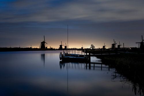 Historische holländische Windmühlen entlang einer breiten Gracht bei Kinderdijk