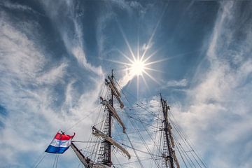 Tweemaster and the sun in the harbour of Lemmer, Friesland. by Harrie Muis