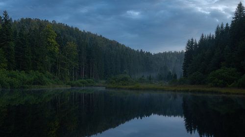 Panorama in het blauwe uur aan een mooi klein meer in de Jura.