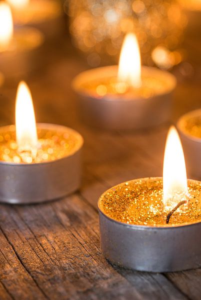 Shiny Christmas time Advent candles with golden glitter baubles decorations by Alex Winter