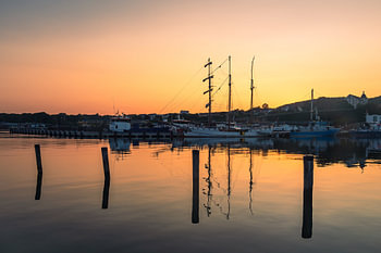 Zeilschip en vissersboot in de haven van Sassnitz op het eiland Rügen bij avond