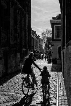 Moeder en kind fietsen onder de Dom