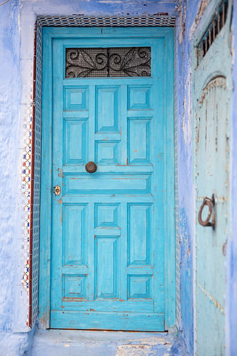 Turquoise panelled door with Moroccan mosaic